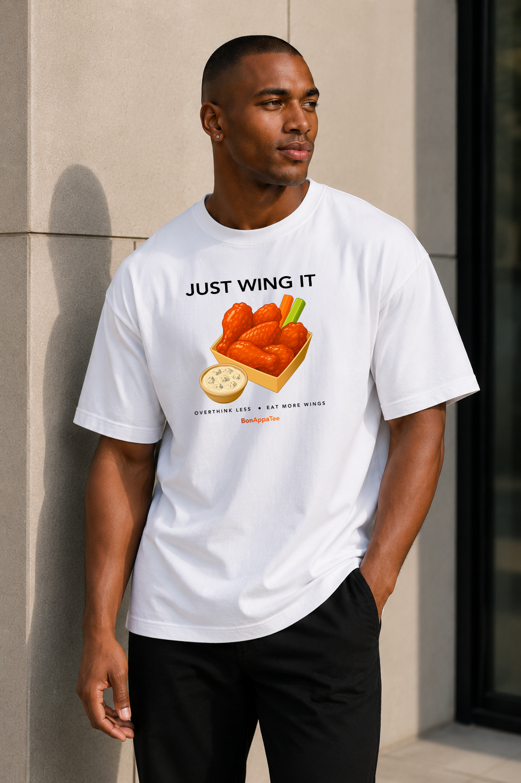 Male model wearing Just Wing It oversized fit — chicken wings graphic t-shirt by BonAppaTee